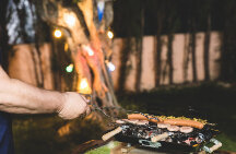 homem assando carne em churrasqueira