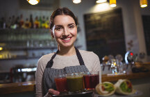 copeira servindo bebidas em cima de uma bandeija